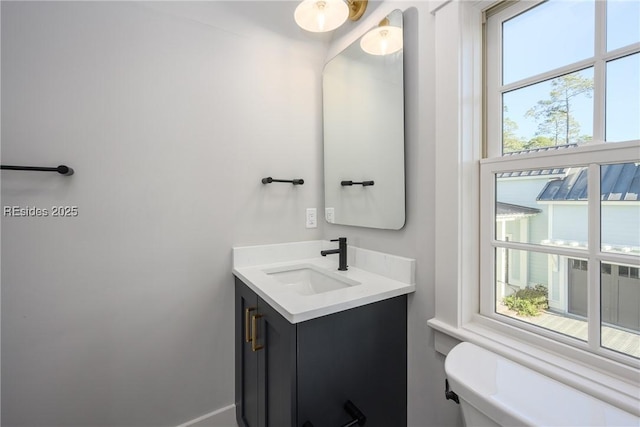 bathroom with vanity, a wealth of natural light, and toilet