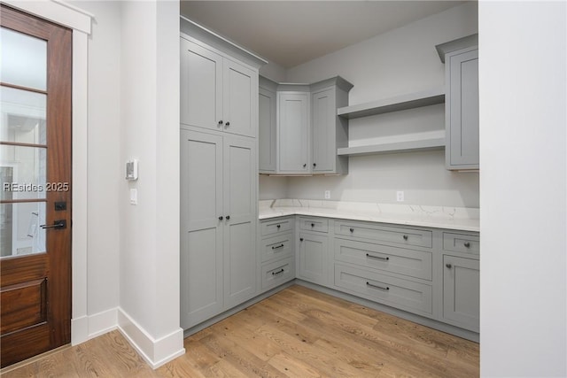 kitchen with gray cabinetry and light hardwood / wood-style flooring