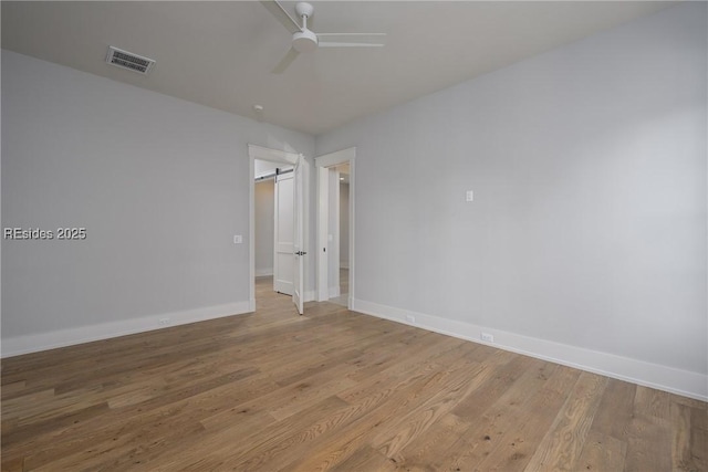 empty room with ceiling fan and light hardwood / wood-style floors