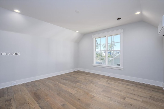 additional living space with lofted ceiling and light hardwood / wood-style flooring