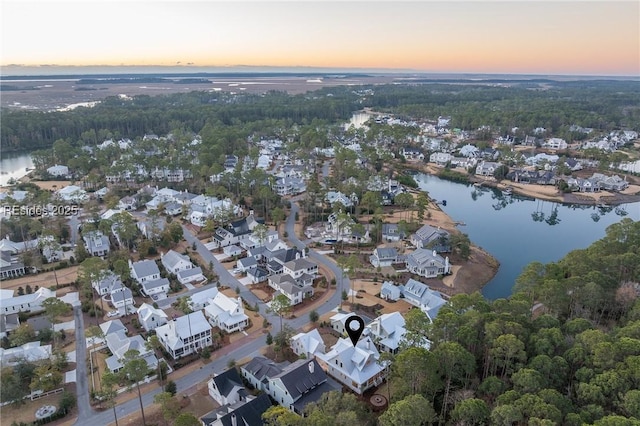 aerial view at dusk featuring a water view