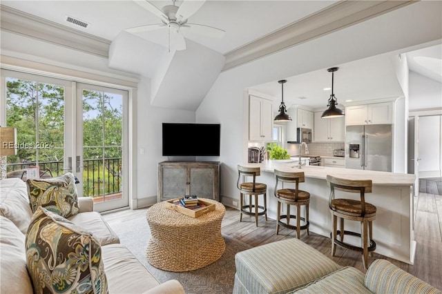 living room with dark hardwood / wood-style flooring, sink, french doors, and ceiling fan