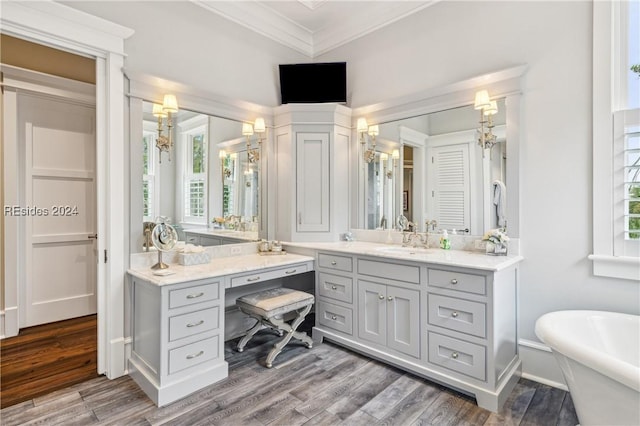 bathroom featuring ornamental molding, a bath, hardwood / wood-style floors, and vanity