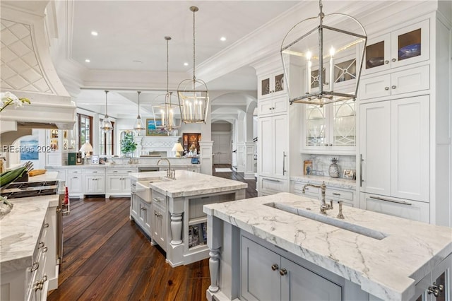 kitchen featuring white cabinetry, hanging light fixtures, light stone countertops, and a spacious island