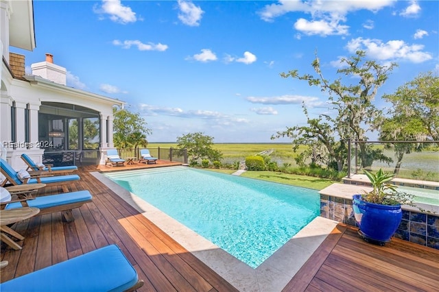 view of pool with a wooden deck and a sunroom