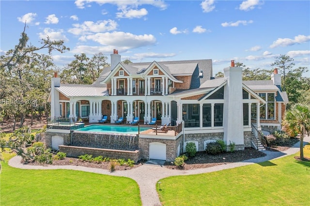 rear view of house with a pool with hot tub, a lawn, a patio, and a balcony