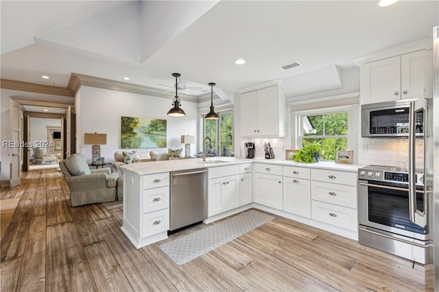 kitchen featuring appliances with stainless steel finishes, sink, white cabinets, and decorative backsplash