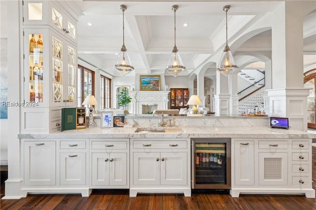 bar with pendant lighting, white cabinets, wine cooler, coffered ceiling, and light stone countertops