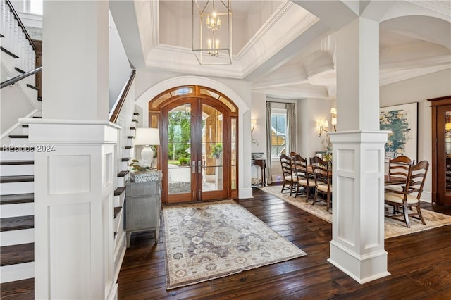 foyer with an inviting chandelier, ornamental molding, dark hardwood / wood-style flooring, and french doors