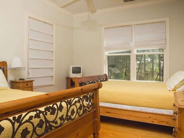 bedroom with crown molding, ceiling fan, and hardwood / wood-style flooring