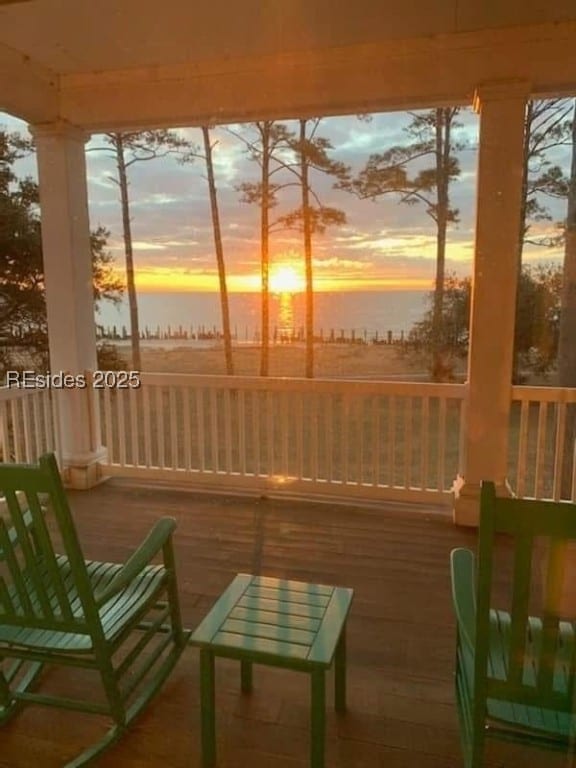 sunroom / solarium featuring a water view