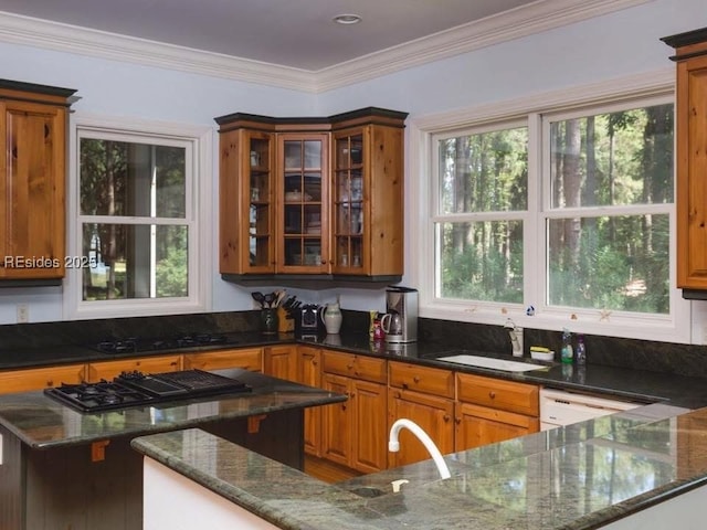 kitchen with dark stone countertops, sink, ornamental molding, and black gas cooktop