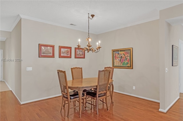 dining space featuring crown molding, a notable chandelier, and light hardwood / wood-style floors