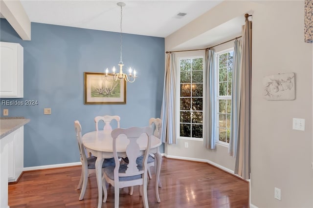 dining space with dark hardwood / wood-style floors and a chandelier