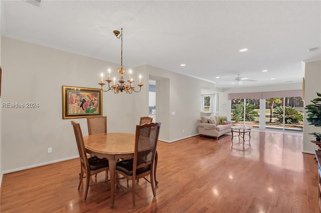 dining space featuring crown molding, ceiling fan with notable chandelier, light hardwood / wood-style floors, and a textured ceiling