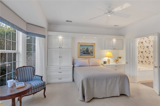 bedroom featuring ensuite bath, light colored carpet, and ceiling fan