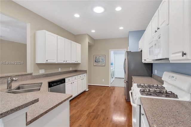 kitchen featuring sink, white appliances, light hardwood / wood-style flooring, white cabinets, and washer / dryer