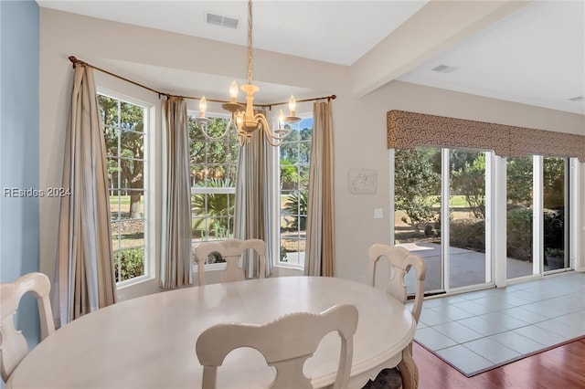 dining area featuring beamed ceiling, plenty of natural light, a chandelier, and hardwood / wood-style floors