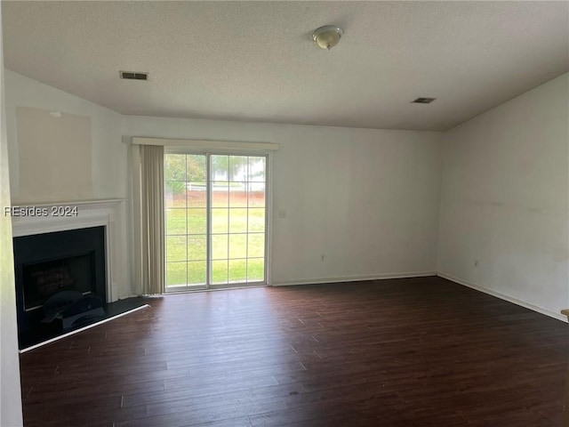 unfurnished living room featuring dark hardwood / wood-style floors and a textured ceiling