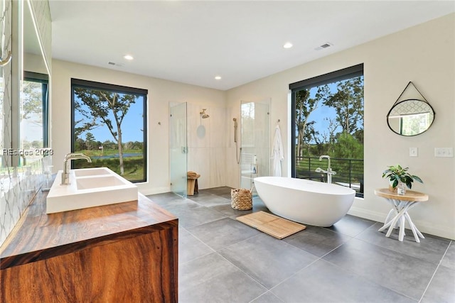 bathroom with concrete flooring, shower with separate bathtub, and vanity