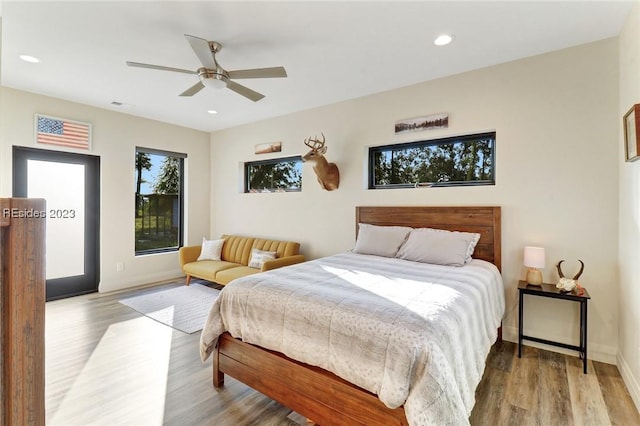 bedroom with multiple windows, ceiling fan, and light wood-type flooring