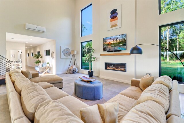 living room featuring a towering ceiling and a wall mounted AC