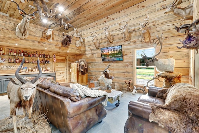 living room featuring indoor bar, wooden walls, wooden ceiling, and carpet