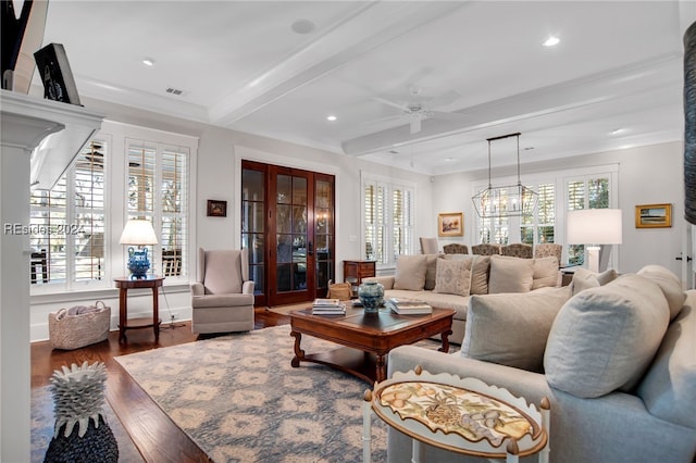 living room with hardwood / wood-style flooring, plenty of natural light, beam ceiling, and crown molding