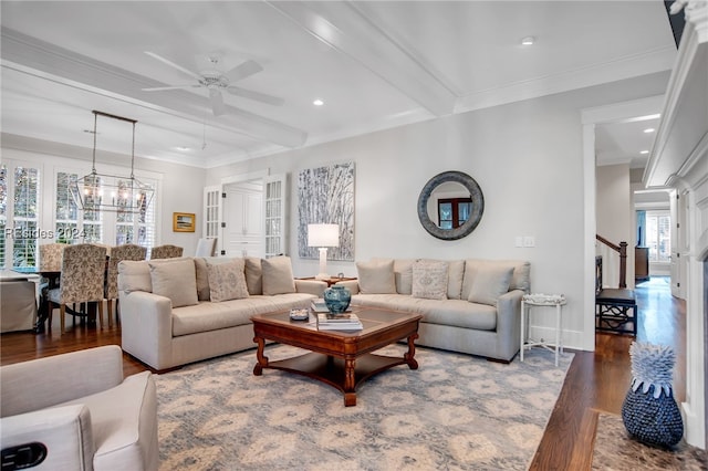 living room with crown molding, plenty of natural light, dark wood-type flooring, and beam ceiling