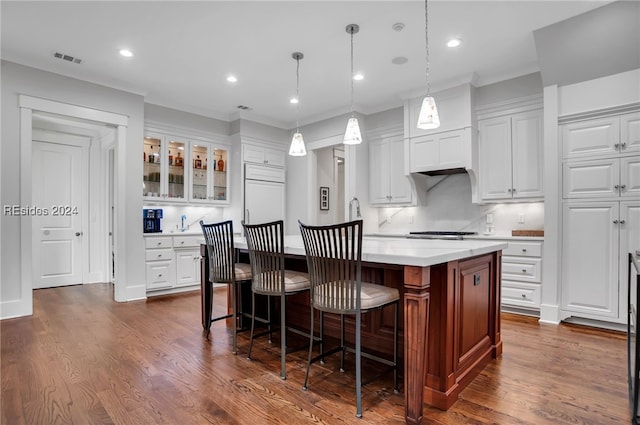 kitchen with hanging light fixtures, a center island, tasteful backsplash, paneled refrigerator, and white cabinets