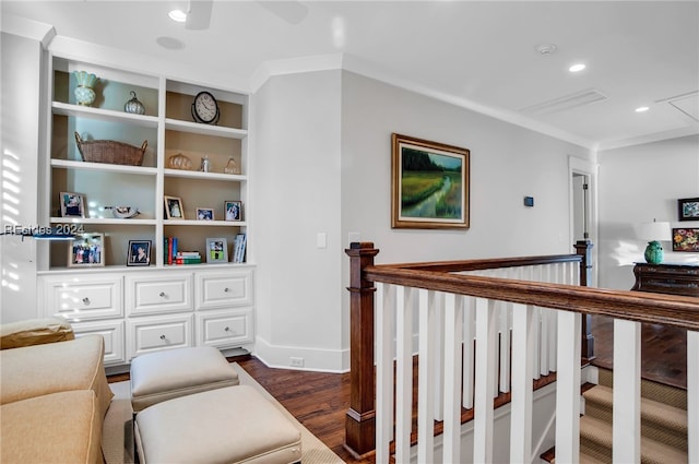 sitting room featuring dark wood-type flooring, ceiling fan, crown molding, and built in shelves