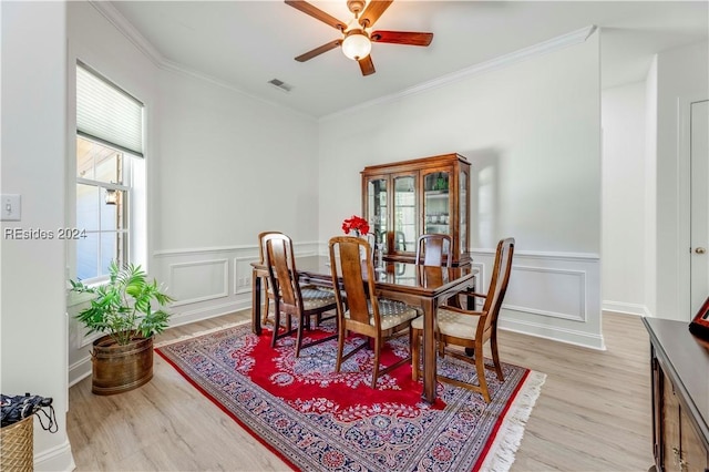 dining area with light hardwood / wood-style flooring, ornamental molding, and ceiling fan