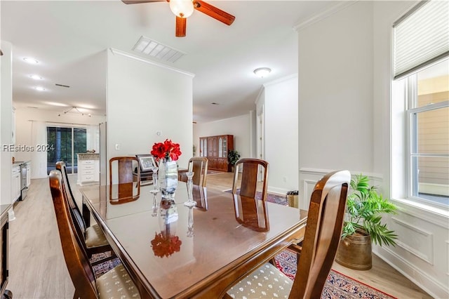 dining area with ornamental molding, light hardwood / wood-style floors, and ceiling fan