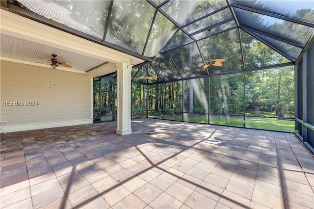 view of patio featuring ceiling fan and glass enclosure