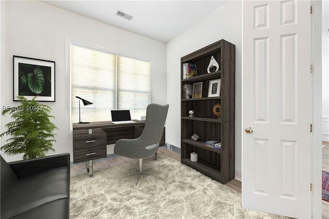 home office with light hardwood / wood-style flooring