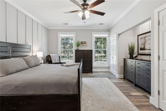 bedroom with ceiling fan, ornamental molding, and hardwood / wood-style floors