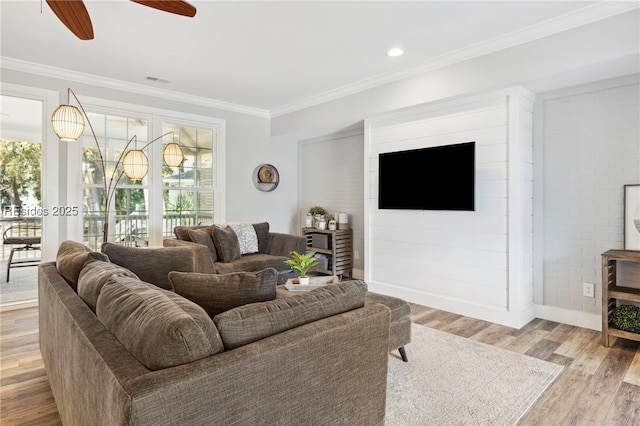 living room featuring ornamental molding, a wealth of natural light, light hardwood / wood-style floors, and ceiling fan