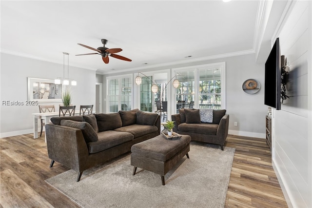 living room featuring crown molding, wood-type flooring, and ceiling fan