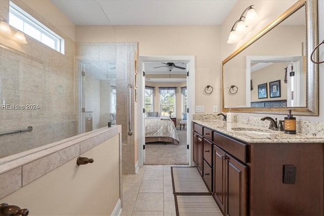 bathroom featuring tile patterned flooring, vanity, plenty of natural light, and a tile shower