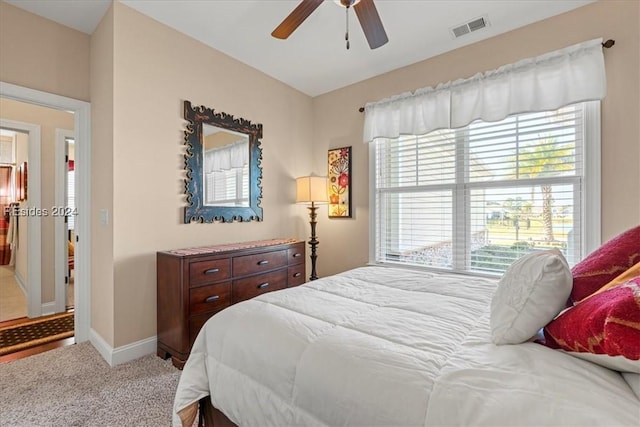 carpeted bedroom with multiple windows and ceiling fan