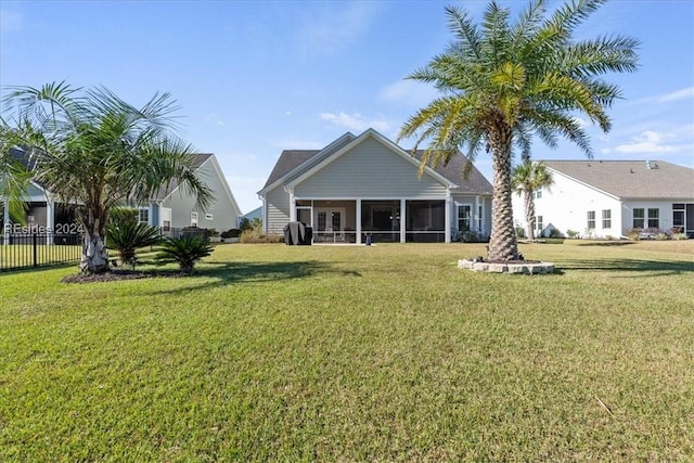 back of property with a yard and a sunroom