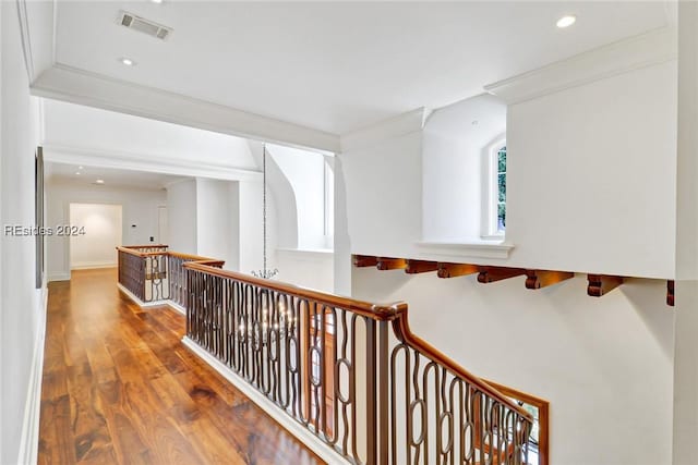 hallway with ornamental molding and hardwood / wood-style floors