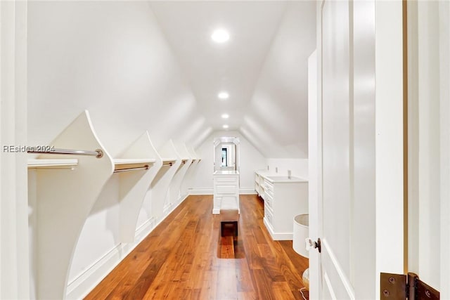 additional living space featuring lofted ceiling and light wood-type flooring