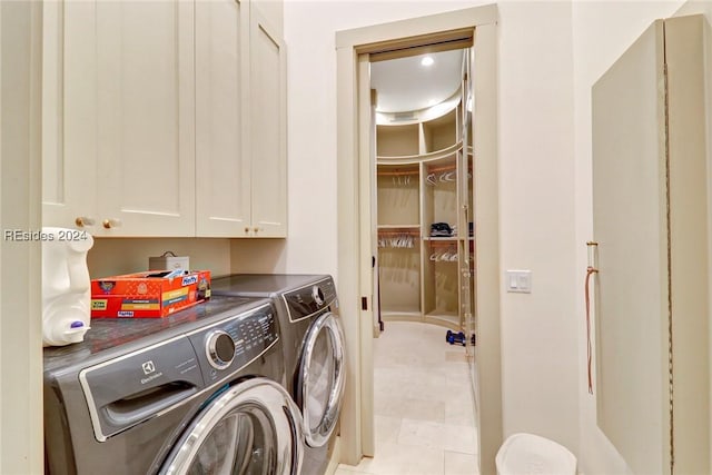 laundry room with cabinets, washing machine and dryer, and light tile patterned floors