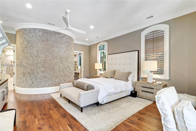 bedroom featuring hardwood / wood-style flooring, ceiling fan, and crown molding