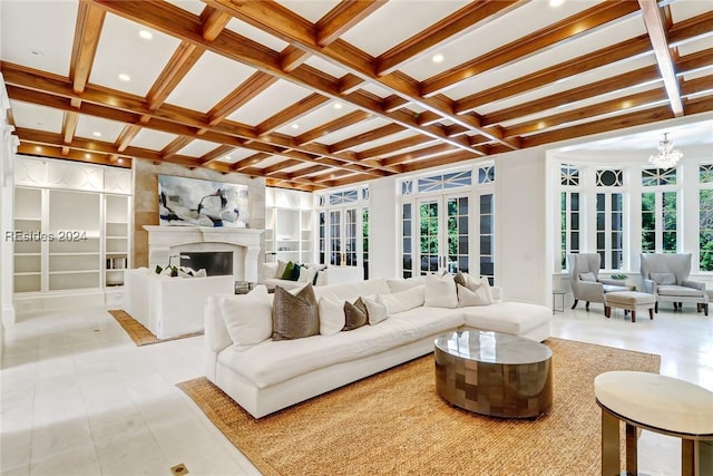 living room featuring beamed ceiling, an inviting chandelier, coffered ceiling, and built in shelves