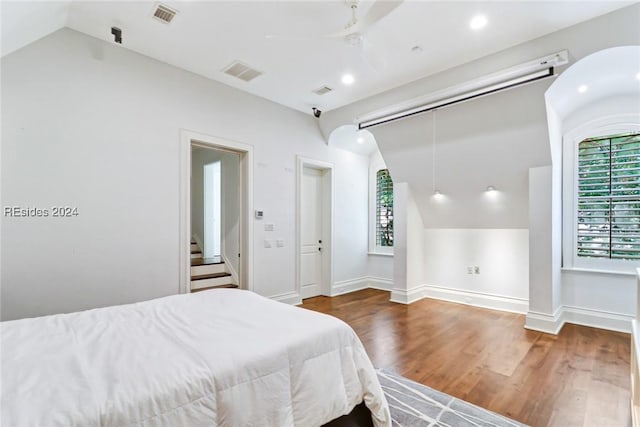 bedroom featuring ceiling fan, lofted ceiling, dark hardwood / wood-style flooring, and a closet