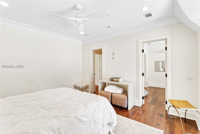 bedroom with ornamental molding, dark hardwood / wood-style floors, and ceiling fan