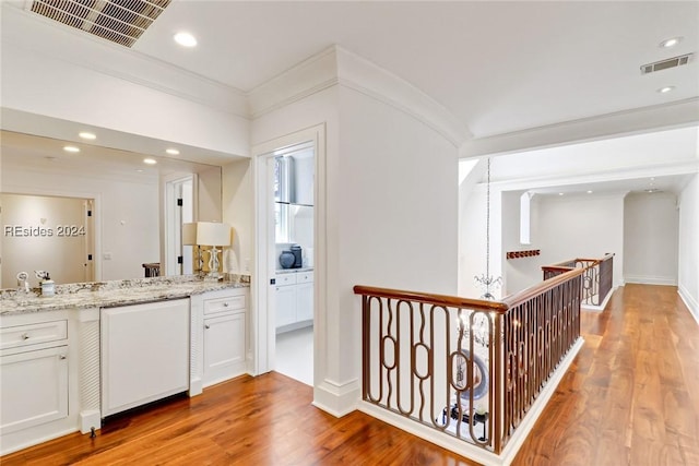 kitchen with white cabinetry, light hardwood / wood-style flooring, and light stone countertops