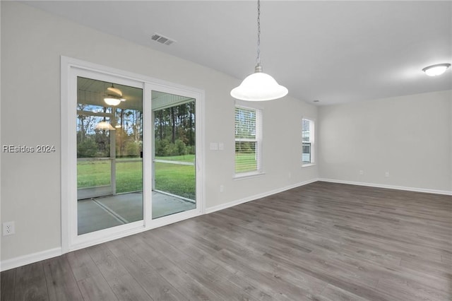 unfurnished dining area with hardwood / wood-style flooring and plenty of natural light